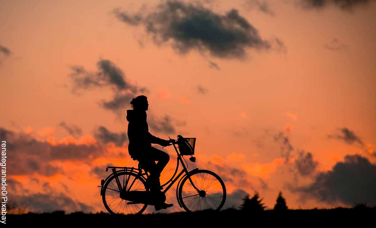 Foto de la silueta de una persona montando en bici que revela lo que es soñar con bicicleta