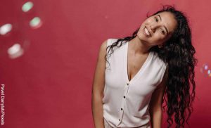 Foto de una mujer sonriente que tiene la cabeza de medio lado que revela lo que es soñar con cabello largo