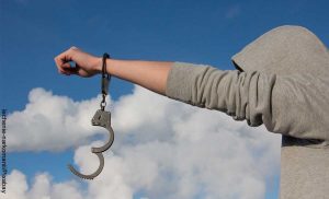 Foto de un hombre liberándose de esposas que revela lo que es soñar con ladrones