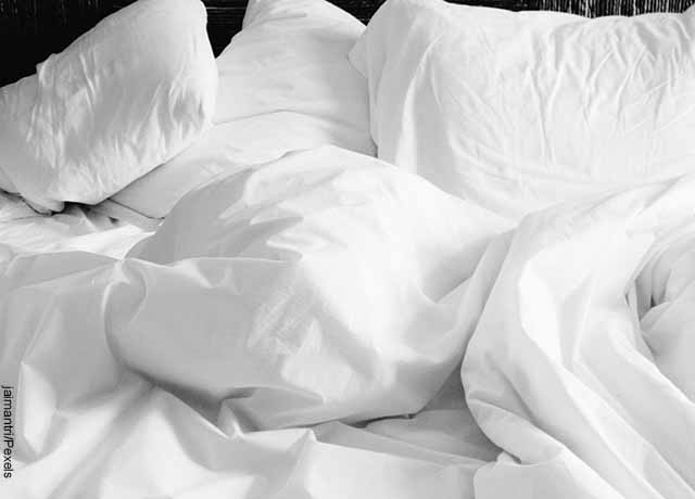 Foto de sabanas blancas de cama que muestran lo que es soñar con orinar
