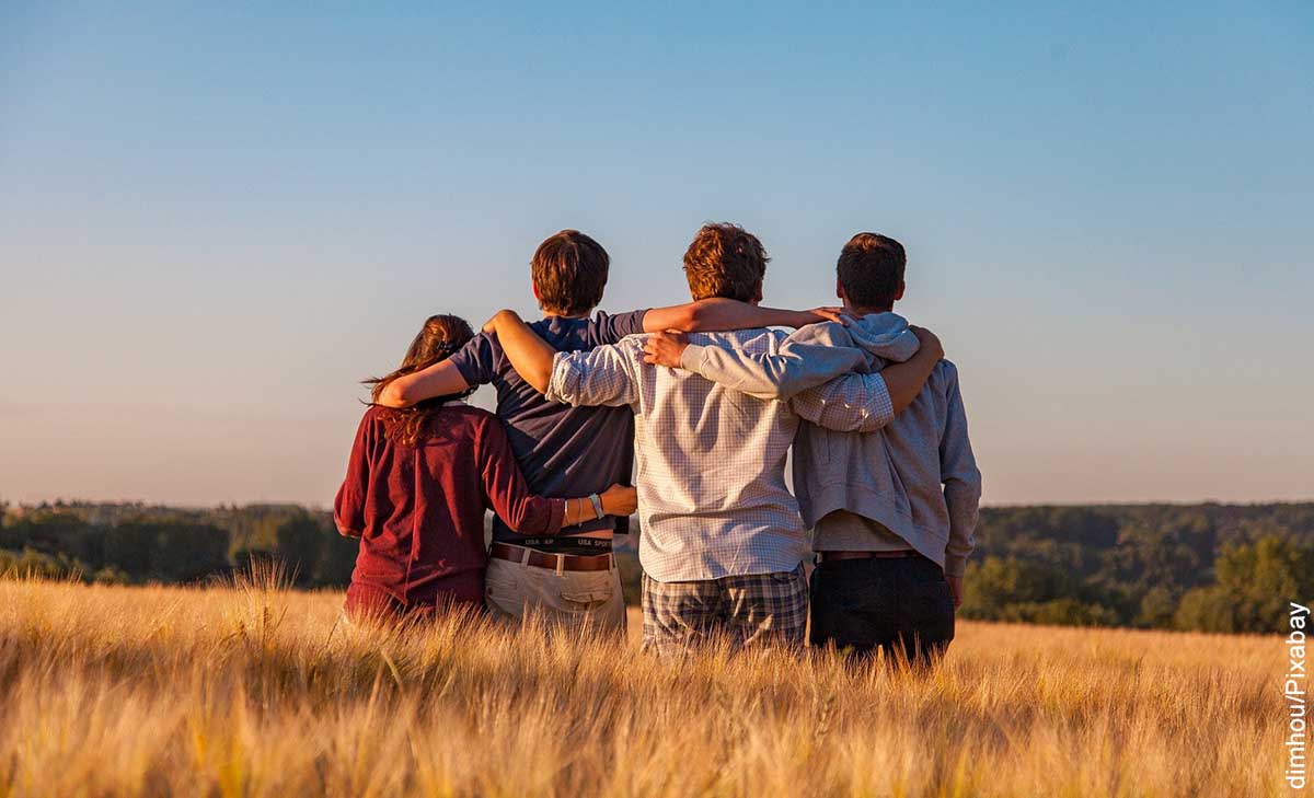 Foto de 4 amigos abrazados de espalda que muestra lo que es soñar con un amigo muerto