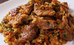 Foto de un plato con carnes que muestra el arroz atollado y su receta