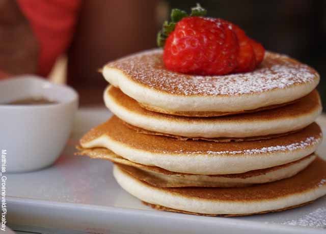 Foto de pancakes sobre un plato con fresas arribas