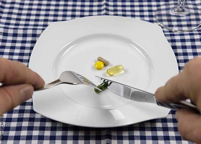 Foto de un persona comiendo píldoras de un plato
