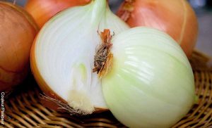 Foto de una cebolla partida a la mitad que revela para qué sirve la cebolla