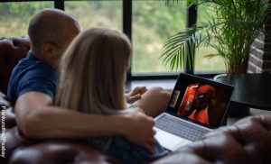 Foto de una pareja sentada viendo el computador que revela las películas para ver en pareja