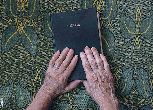 Foto de las manos de una anciana sobre la biblia que muestra las estrella de 6 puntas y su significado