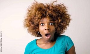 Foto de una mujer sorprendida que muestra el número 33 en los espiritual