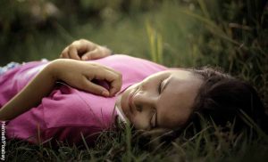 Foto de una mujer acostada en el césped que revela qué es la inteligencia emocional