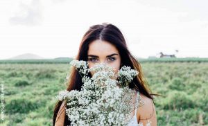 Foto de una mujer con flores en sus manos que revela lo que significa soñar con flores blancas