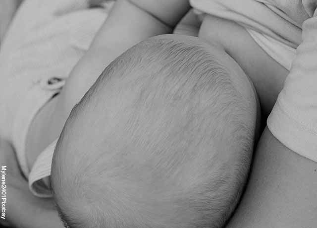 Foto de un bebé tomando leche del pecho de su madre