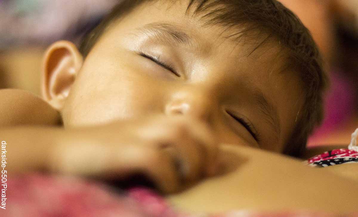 Foto de un bebé durmiendo que revela lo que es soñar con leche materna