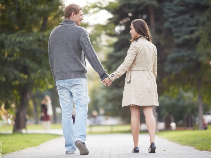 Foto de una pareja caminando en el parque agarrados de la mano para representar el significado del 444 en lo espiritual