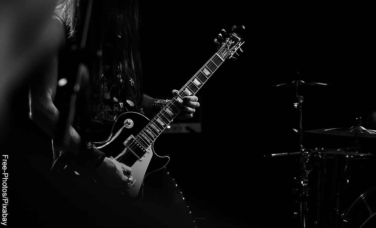 Foto de un músico tocando la guitarra eléctrica que revela las canciones de rock para dedicar