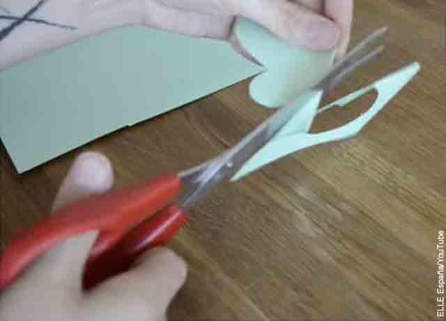 Foto de una persona cortando papel con tijeras