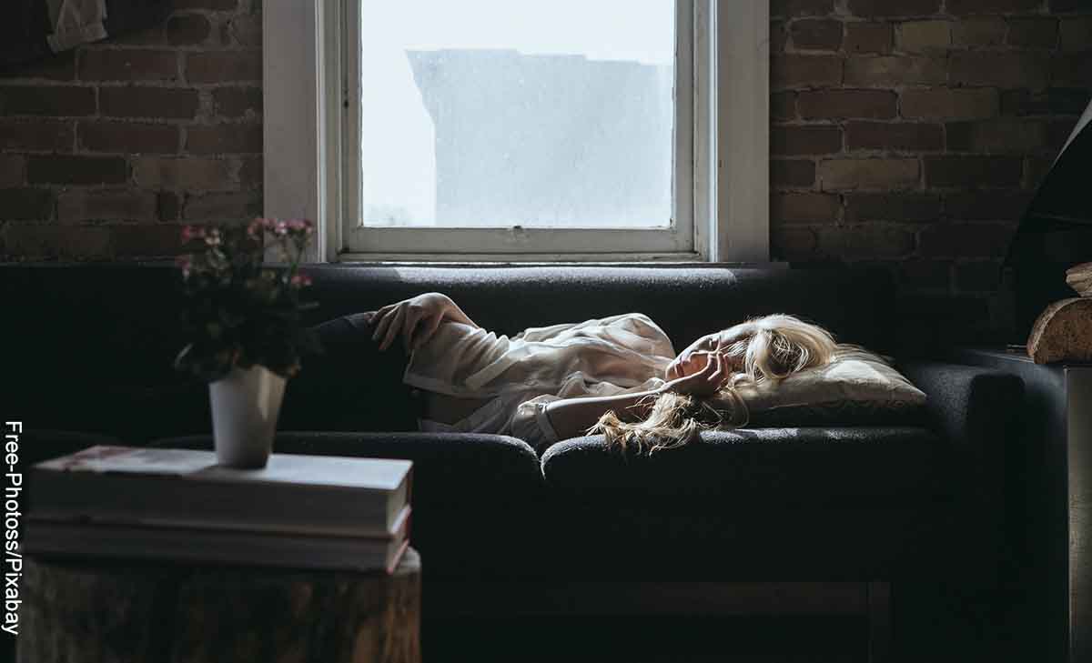 Foto de una mujer dormida en el sofá que revela cómo saber el significado de un sueño