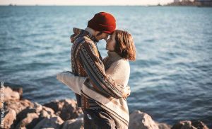 Foto de una pareja abrazada frente al mar que muestra las películas de comedia romántica