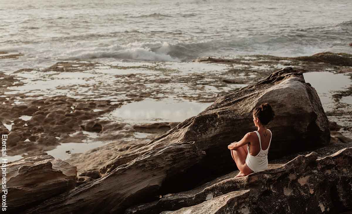 Foto de una mujer meditando frente al mar que revela qué significa 10 10