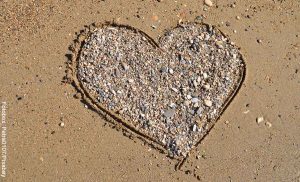 Foto de un corazón hecho con piedras en la playa que revela qué significa 11 11 en lo espiritual
