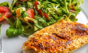 Foto de un filete de pechuga y una ensalada que revela las recetas fáciles con pechuga de pollo