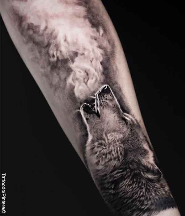 Foto de un brazo tatuado con un lobo aullando