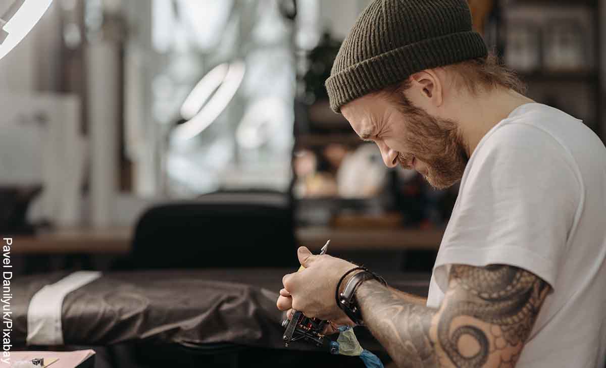 Foto de un tatuador alistando su máquina que revela el significado de tatuajes de lobo