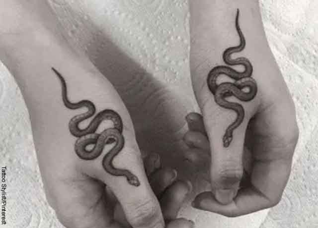 Foto de dos manos con tatuajes que revelan el significado de tatuaje de serpiente