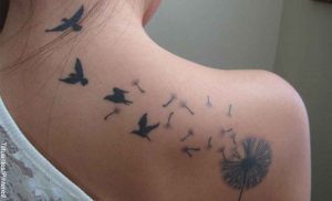 Foto de una mujer con tatuaje en su espalda que revela el significado del diente de león en un tatuaje