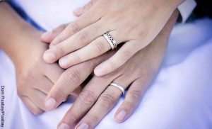 Foto de dos manos entrelazadas que muestran soñar con un anillo de compromiso