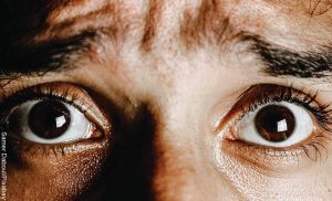 Foto de los ojos de un hombre asustado que revela lo que es soñar con culebras negras