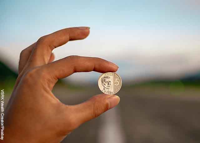 Foto de una persona sosteniendo una moneda que revela lo que es soñar con monedas en la mano