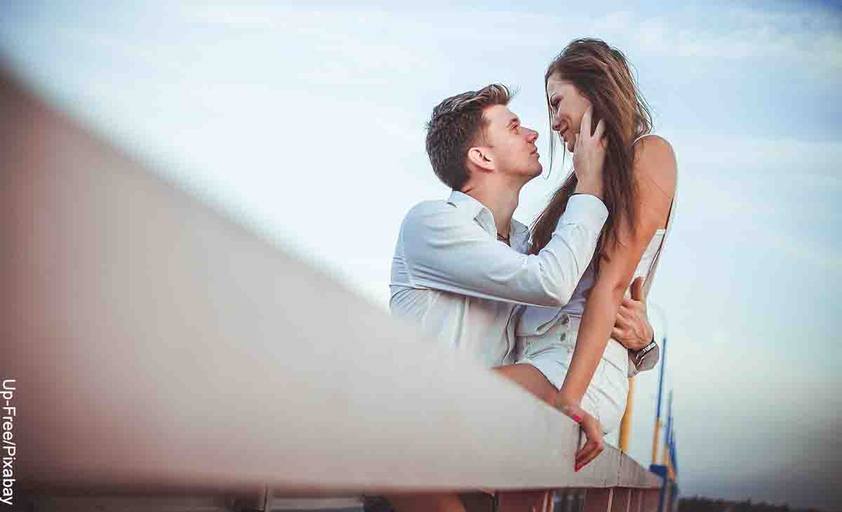 Foto de un hombre sosteniendo a su pareja en las piernas que revela las canciones para dedicar a tu novio