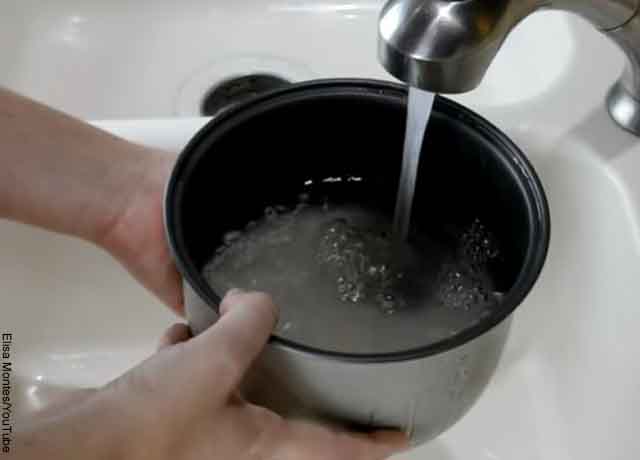 Foto de una persona lavando arroz