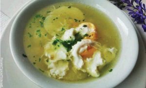 Foto de un caldo con papa en un plato blanco y que revela cómo hacer caldo de huevo