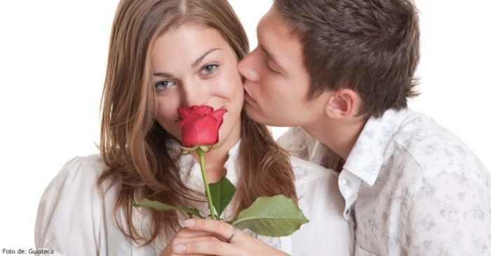 Foto de un hombre besando en la mejilla a una mujer