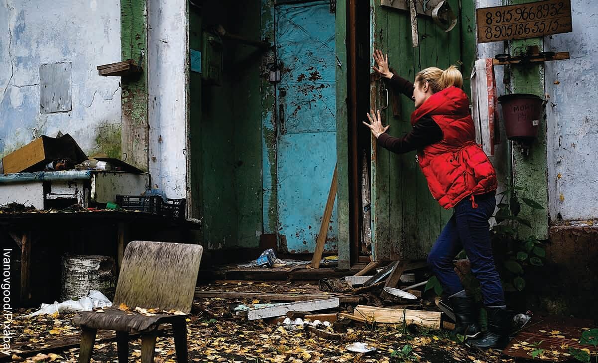 Foto de una mujer cerrando una puerta en casa que revela las mejores películas de terror