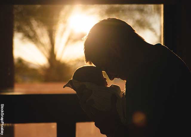Foto de un padre cargando a su hijo que muestra qué significa soñar con tener un bebé