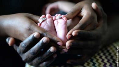 Foto de una persona sosteniendo los pies de su hijo que muestra qué significa soñar con tener un bebé