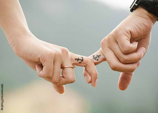 Foto de una pareja agarrada por un dedo de sus manos