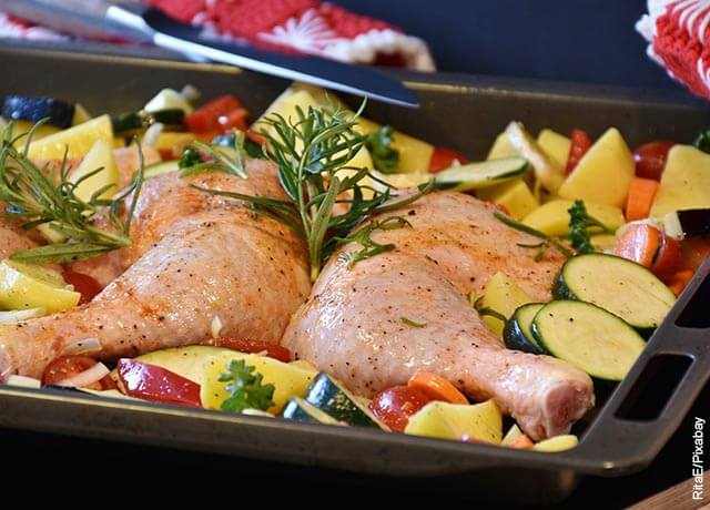 Foto de piernas y perniles de pollo con verduras que revela las recetas con muslos de pollo