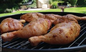 Foto de piernas y perniles de pollo en un asador que revelan las recetas con muslos de pollo