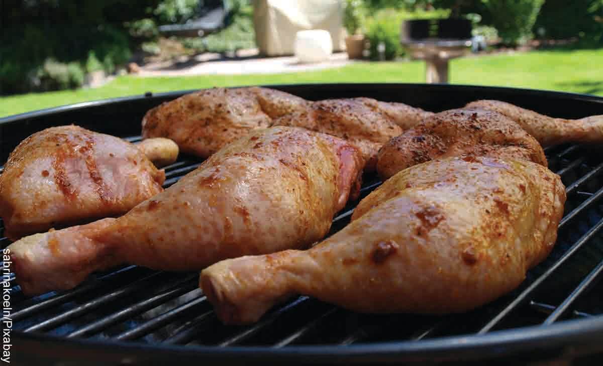 Foto de piernas y perniles de pollo en un asador que revelan las recetas con muslos de pollo