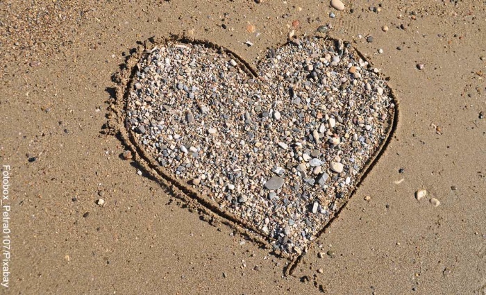 Foot de un corazón en la arena