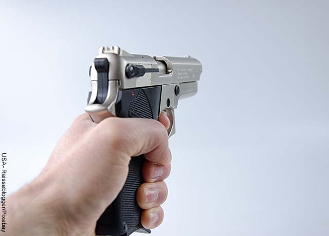 Foto de una persona sosteniendo un arma