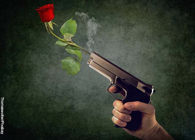 Foto de una pistola con una rosa