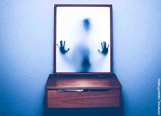 Foto de un demonio frente a un espejo que revela lo que es soñar con demonios