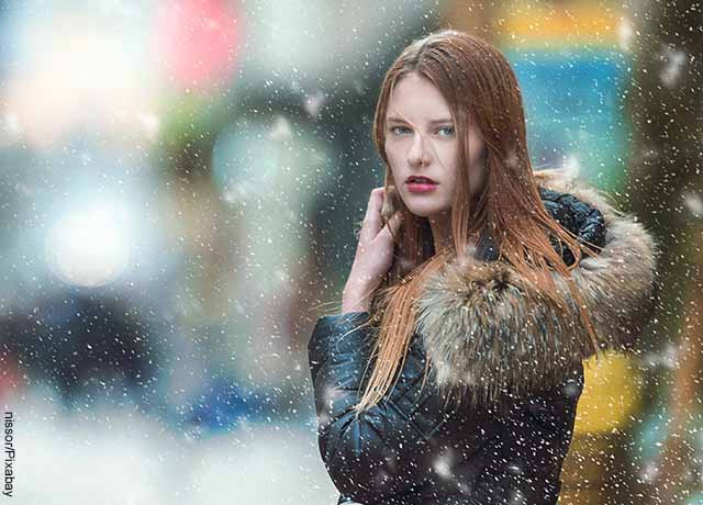 Foto de una mujer en medio de una nevada que muestra lo que es soñar con nieve