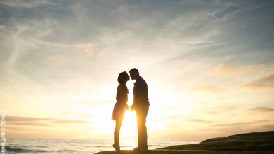 Foto de una pareja besándose en una playa que muestra las canciones románticas para dedicar