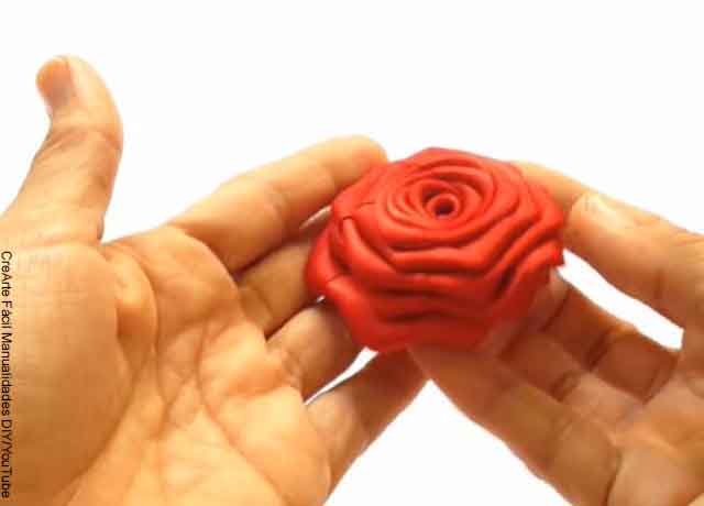 Foto de una rosa hecha en cinta en las manos de alguien