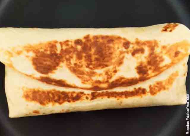 Foto de un burrito sobre una plancha de cocina